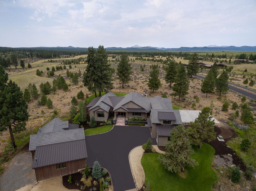 Spectacular views of Mt. Bachelor greet you from this private 10 acre oasis in the heart of NW Bend. From the interior to exterior design, this property provides a setting that welcomes year-round entertaining while also embracing the quiet high desert surroundings when it's time to recharge. This predominantly single level home built in 2016 features modern farmhouse character with timeless designer finishes. The open floor plan is anchored by a gourmet kitchen with a double Thermador refrigerator and 6 burner Wolf range. Five bedrooms on the main level with the primary suite thoughtfully designed around the views of the Cascade Range. Spa inspired bathrooms through out with heated floors, a soaking tub & walk in shower in the luxurious primary suite. Upstairs, a versatile flex space offers options for a home office, guest suite, bonus room, or gym. Outside boasts an expansive lawn, 32 foot RV garage, covered family room with  a wood burning fireplace, sport court, & 19 foot pool/spa.