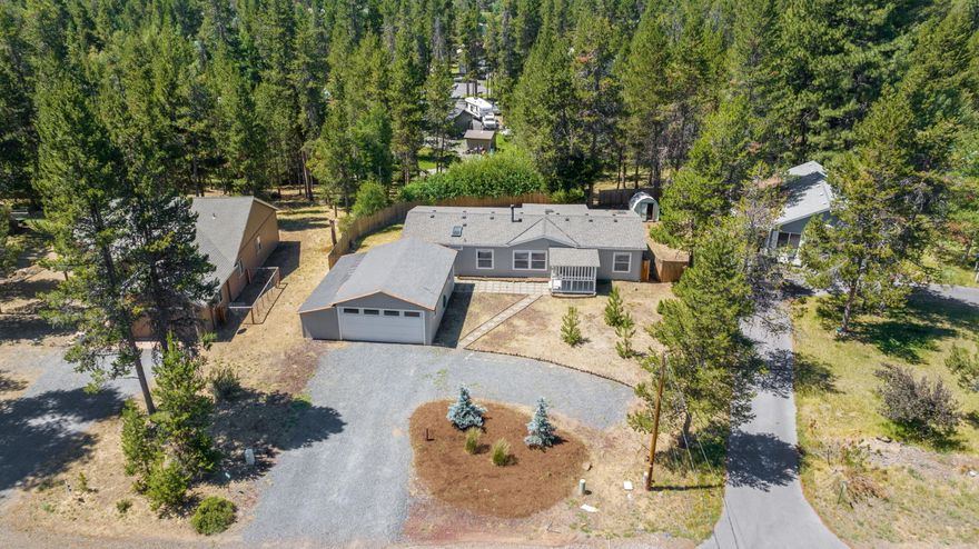 Discover the perfect blend of privacy, convenience, and outdoor adventure from this idyllic location in Oregon Water Wonderland! This clean manufactured home sits on nearly a half-acre full of opportunity to create your own oasis, with easy access to Mt. Bachelor and endless recreation while only a 30-minute drive to Bend. The HOA maintains paved roads throughout as well as a community marina on the Deschutes River that is within walking distance. No septic or well to worry about - this property is on community sewer and water. Inside the home, large windows offer abundant light while a wood stove makes it cozy in winter. The home also has new kitchen countertops and a newer roof, an oversized two-car garage and space to park an RV.  Outside, the fenced yard offers privacy and space to garden or relax and enjoy the quiet setting. This property is an ideal vacation spot, rental or year-round residence. Outside of town yet close to amenities, this home offers the best of both worlds!