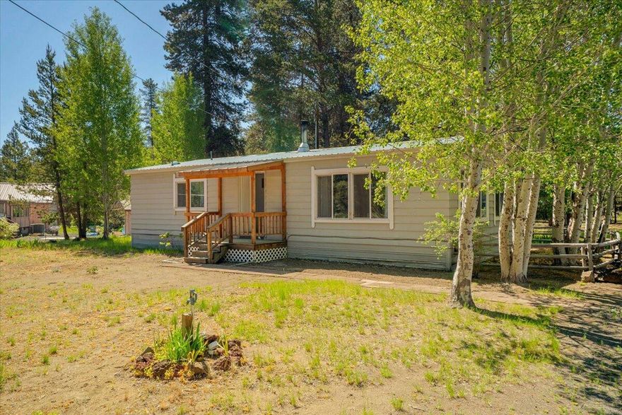 Welcome to this charming 2-bed, 2-bath home, nestled on a 1-acre treed lot, offering 1,056 sqft of comfortable living space. As you arrive, you'll appreciate the convenience of the circle driveway and the detached garage, perfect for additional storage or parking. The property also features a handy pump house for the well and water softener, with storage space and a wood shed, ideal for all your outdoor equipment needs.
Inside, find a bright and inviting interior with professionally cleaned carpets. The dining and living areas are bathed in natural light, creating a warm and welcoming environment for family and friends. The wood stove with a fan heats the whole home in the cooler months, significantly lowering the heating bill. 
Venture outside to the back patio, designed with sturdy beams to support snow during winter months, allowing you to enjoy this space year-round. The beautiful trees surrounding the property offer a serene and private setting, making this home your oasis!