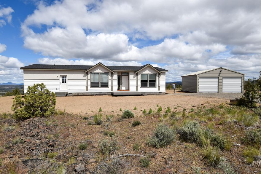 Seller is offering $10k towards closing costs! Welcome home to living large in your brand-new St. Andrews home set on 1.88 +/- acres with panoramic mountain and Bend city light views! The St. Andrews plan is 1,856 +/- sq ft with 3 bedrooms and 2 baths separated by the spacious kitchen and great room area allowing for maximum privacy. The oversized primary suite has a large private bathroom with separate soaking tub and spacious shower plus a huge walk-in closet! The large kitchen boasts a unique breakfast nook and bar counter making it perfect for entertaining. The kitchen also has the stainless appliance and energy star package.  Let's not forget the upgraded sliding glass door off the dining room where you can go out and relax on your beautiful Trex deck.  Lastly this home is heat pump ready, has a 24' by 25 detached garage with power, shared well and an ATT septic system. Come make this your new forever home!