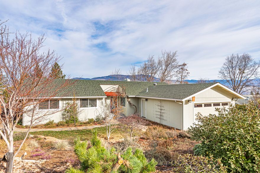 Updated single-level home with beautiful mountain views located nearby hiking trails, groceries, restaurants, and shops! Features include red birch hardwood floors, abundant natural light from double-paned windows, Hunter Douglas blinds, remodeled kitchen with granite dining counter, mosaic tile backsplash, wood cabinetry, 4-burner gas range, convection oven, stainless appliances, two wood-burning brick fireplaces, partially covered composite view deck with access via sliding glass doors from dining and living room, primary bedroom with access to private composite deck and hot tub, renovated en-suite bathroom with dual vanity quartz counter, spacious tiled shower, two additional guest bedrooms, updated full guest bathroom, and two car garage. Grounds include sunny gardening areas, stacked stone retaining walls, paver patio and entry, stone and decomposed granite pathways with corten steel edging. Inquire with agents for documentation and details of offer submission deadline!
