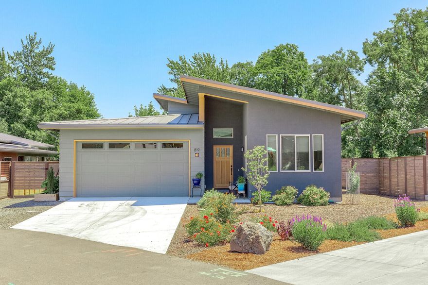 Single level Northwest contemporary home in a highly desired location. This Verde Village home has an open floor plan, vaulted ceilings and wonderful natural light. Hickory hardwood floors fill the great room, creating a great flow of space. The kitchen has stainless steel appliances and a large central island with a breakfast bar. The great room opens to the back patio, making this the ultimate indoor/outdoor living space. The primary suite has wonderful corner windows allowing the light to fill the space. There is also en suite bathroom with soaking tub and a walk-in closet. Another bedroom and full bathroom round the wonderful interior space. This Earth Advantage Platinum (2018 standards) home, is PV ready to hook up to solar. Located in a wonderful neighborhood of like homes. It is next to the Bear Creek bike path and dog park and less than a milt to the Plaza. There are 7 years remaining on the home warranty.