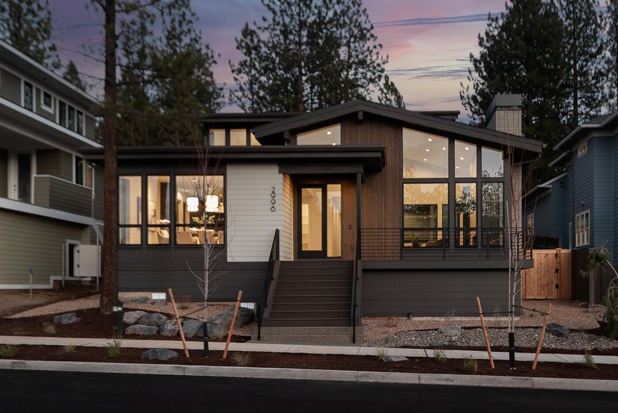 Structure Development NW presents a stunning mid-century modern home in Bend's westside Talline community. Clean lines, warm finishes, and expansive windows fill the interior with natural light. The open layout features four bedrooms, 2.5 baths, and a versatile den, blending style with functionality. A masonry-clad fireplace anchors the great room, complemented by hardwood floors throughout the main level and stairs. The gourmet kitchen boasts custom cabinetry, high-end appliances, and an oversized island ideal for entertaining. Retreat to the main-level primary suite with its spa-like bath and walk-in closet. A flexible den and fourth bedroom provide room to adapt, while the three-car garage with Sprinter bay offers abundant storage. The covered patio invites year-round outdoor living against a mountain backdrop. With access to trails, parks, and westside amenities, this residence is a modern masterpiece designed for Bend's lifestyle.