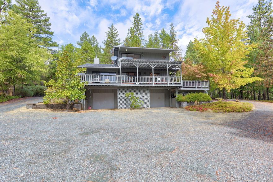 Nature surrounds you in this spacious 2bed 2bath 1602 sqft home. As you travel up the long wrap around driveway you are greeted by this beautiful home nestled into the hillside and positioned for the best possible views! The living room is open concept, complete with large picture windows and a wood stove. The sliding glass door off of the dining room will take you onto the large wrap around deck which is perfect for outdoor entertaining. Back inside on the main level you'll find a well laid out kitchen, an office nook with attached laundry room and a bedroom that could be used as a first floor primary with an attached bath. Upstairs leads you to the expansive loft style master suite, with its own private deck, soaking tub and large walk in closet. The basement level is taken up entirely by a large garage with ample work shop space it's also where you will find the whole home backup generator. There is also a second detached garage which includes covered RV parking.