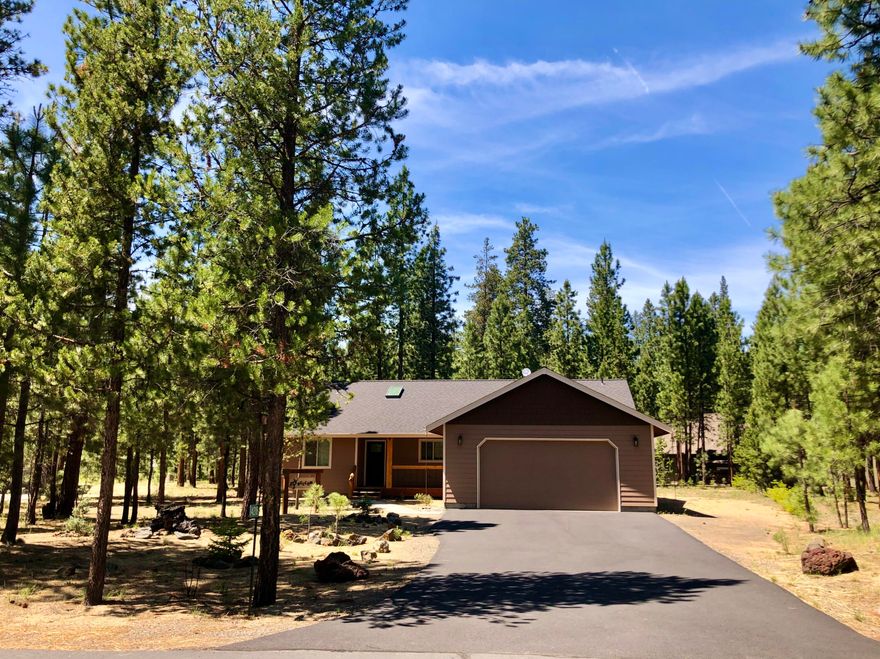 Experience spectacular Central OR seasons in this near-new, single level 3 BR/2BA Big Deschutes River community custom home!  Rarely lived-in owners' 2nd home equipped w/smart thermostat and heat pump for year-round climate control.  Home is loaded with NW craftsman elements, including hickory cabinets, granite kitchen counters, eating island, solid knotty pine doors and trim work thru-out, plus cedar decking to host gatherings for family and friends.  Ensuite master bedroom w/barn door to private bath + big walk-in closet occupies the east wing of the comfortable floorplan.  Open great room w/skylit vaulted ceilings & pellet stove fireplace orients to a covered rear patio, flagstone walkway to a cozy gathering area, and gentle swing overlooking forested common area and miles of National Forest!  Oversized double garage for vehicles and recreational items galore. Just footsteps to nature trails and scenic Pringle Falls, the beautiful Wild River community welcomes you home!