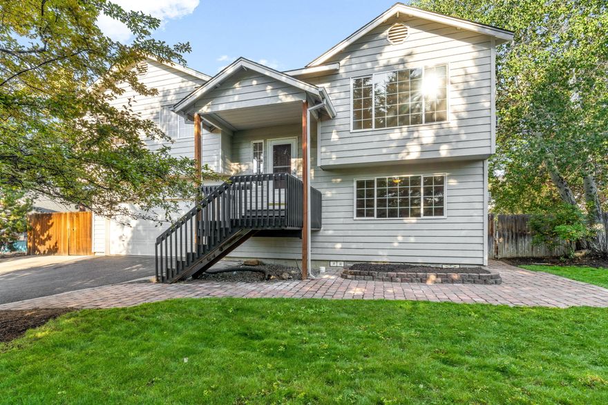 Tucked quietly off the street on a spacious in-town flag lot, this charming home offers privacy and convenience. Outside, enjoy mature landscaping with multiple types of fruit trees, a fenced backyard, and a paved RV parking space. The split-level layout inside features natural light throughout, with living room, kitchen, and all three bedrooms upstairs. Downstairs offers a large bonus living area and a flexible space that could be a home office.  Recent upgrades include new carpet, fresh interior paint, new bathroom flooring, newly painted decks, and refreshed landscaping. Stay comfortable year-round with forced air heating and central A/C. Take in sunset views from the kitchen and back deck, all just minutes from medical facilities, parks, schools, shopping!