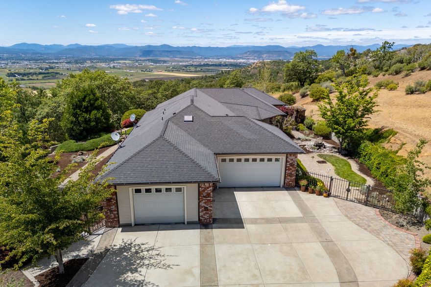 Open and spacious single level contemporary style home with fabulous valley views and close-in privacy. Fully fenced and gated with meandering drive, low maintenance landscaping, outdoor BBQ area, covered patio, pergola with hot tub, firepit, water feature and more. This home was built for entertaining with grand entry, 9 & 10ft ceilings, open living room with corner gas fireplace and built-in entertainment center. Porcelain & Travertine tile flooring throughout, formal dining with French doors to outdoor patio, center island cook's kitchen with Cherry wood cabinets, slab Granite counters, double ovens, wine cooler, prep sink, trash compactor, breakfast bar & walk-in pantry.  Private primary suite offers see-thru gas fireplace, double vanity, jetted tub, water closet, walk-in closet, tiled walk-out shower and Cedar Sauna.  Great built-ins, pendant lighting, in-home office, full guest suite, powder room, central vac system, 3-car garage and room for all your toys!