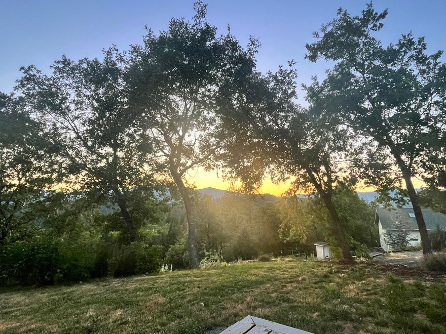 Million dollar views are yours daily from your end of road mountaintop retreat. Enjoy sunrises and sunsets surrounded by over 22 forested acres well kept by the owner, who was a forester. A fenced and gated area encloses this custom Longhurst home built on a ridge with no neighbors close by. There are stunning views in nearly every direction. Enjoy soaring ceilings with a wood stove in the great room and a lovely kitchen with another great view. The primary suite, on its own floor, offers a wood stove, a private balcony, large walk-in closet and a bathroom with a deep jetted tub and step in shower. The attached garage has lots of storage. And wait-there's more.  Shop built in 2019 provides 1155 SF and 14 ft ceilings with an oversize roll up door and covered carport to park your toys or RV. There are fruit trees planted and a garden area. Generator stays. Sit outside and enjoy quiet evenings where the only sound is the whisper of the wind.