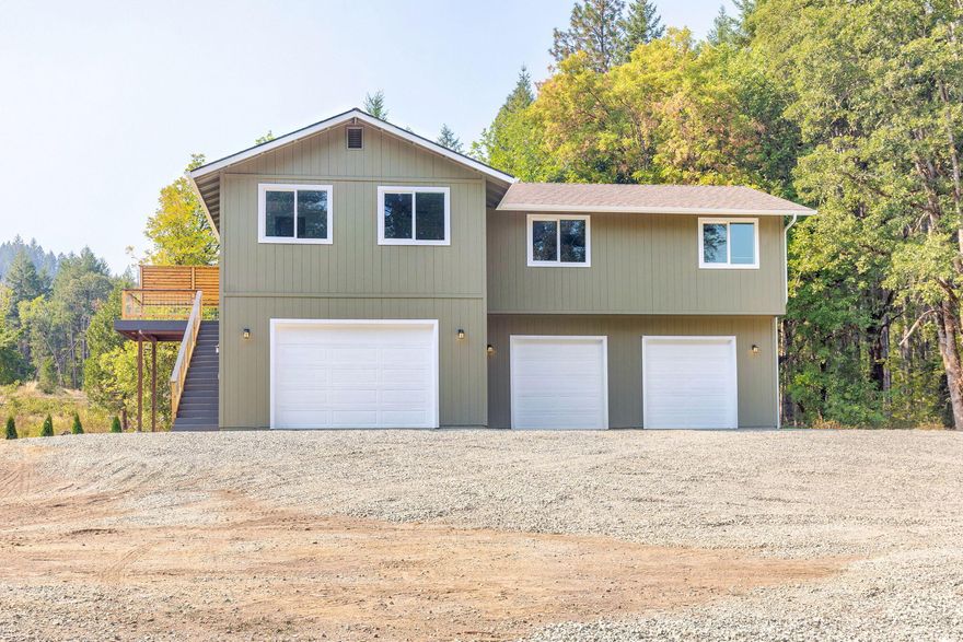 Welcome to this inviting 3-bed, 3-bath home nestled on 5.79-acres on a seasonal creek in Southern Oregon's beautiful Sunny Valley!  Built in 2018, this home just received its finishing touches and feels brand new!  Featuring a spacious 3-car garage with full bathroom below, open-concept living space above is filled with natural light and includes Montage Grey Ridge Luxury Vinyl floors throughout. The kitchen boasts modern appliances, granite counters, Aged Bourbon Cherry cabinets, and a breakfast bar for casual dining. Primary suite includes an en-suite bathroom with tiled shower & walk-in closet.  Enjoy the outdoors on your private deck or patio ready for your hot tub, plenty of room to build your dream shop with power already run to a potential building site.  Quick access to I-5 freeway making for a short commute to Merlin or Grants Pass.  Call and schedule your tour today!