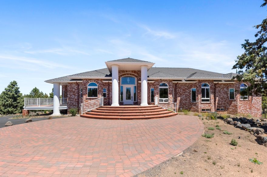 Magnificent colonial brick home sitting on a large private 6.45 acre lot with 2.5 acres of COID irrigation. Perfectly placed, you will enjoy territorial and mountain views from every window. This home is light and bright with an open concept floor plan.  The 3,875 main floor features the large primary bedroom with spa like en suite, two additional bedrooms a formal dining area, den and large living room with vaulted ceilings, fire place and bar.  The gourmet kitchen is a chef's dream! The 1099 sq foot daylight basement is fully finished with one bedroom, den, two full baths and kitchenette.  With 2,653 of garage space, this home has a large 4 car garage and massive RV garage. Your cars will live in as much style as you!  All of this is connected with a convenient elevator to make unloading groceries a breeze!  The lot is zoned SR 2 1/2 with potential for subdividing.  If you are looking for a family compound you need look no further!