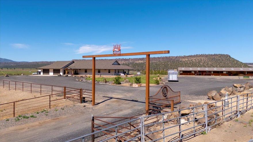 This exceptional custom ranch blends modern elegance with rural charm, just minutes from Prineville. Enjoy breathtaking views of the Crooked River Valley from the beautifully designed single-level home, featuring hardwood floors, granite countertops, a copper farmhouse sink, and a chef's kitchen with a spacious island, stainless steel appliances, and the butlers pantry provides ample storage. The great room and expansive covered back patio with a fireplace, swim spa, and lush landscaping create an entertainer's dream. The private primary suite boasts a spa-like bath, a huge walk-in closet, and peaceful views. A generous den offers flexibility as an office or extra bedroom. Equestrian enthusiasts will love the six-stall barn with large runs, tack room, roping arena, and cattle turnouts. A 3-bay shop provides abundant storage and workspace, and guest quarter. Whether you're seeking a working ranch or a private retreat, this property offers the perfect blend of comfort and functionality.