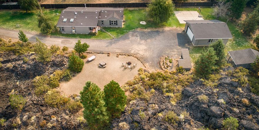 Fabulous 1+ acre property backing up to lava flows and public lands boasting tons of privacy! Pride of ownership shows throughout this beautiful 1926 sq. ft. 4 bed, 2 bath home with tons of natural light. Enjoy multiple living spaces and room to spread out in the large dining, family and living room w/ gas fireplace. Many updates including cedar decks, new exterior paint, flooring, skylights, baseboards, trim package, hardware, fixtures & faucets, lighting, bathroom vanities & mirrors, closet and pantry shelving, and so much more. Large master suite featuring double vanities, large soaking tub and nice separation from other bedrooms. Outside enjoy ample lawn space, concrete pad, private sandy outdoor area w/ firepit perfect for lounging. Outbuildings include heated 2 car detached garage, fancy well house, charming chicken coop w/ storage area, and plenty of room to build an additional garage/shop. See attached 3-D interactive tour to see this home and property!