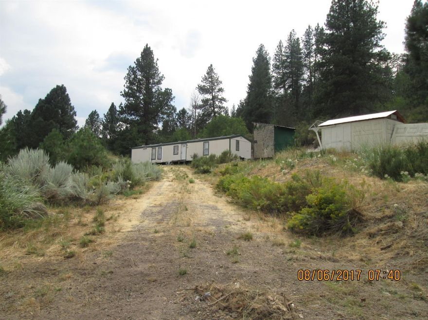 80 GPM well per 2002 well log and backs up to National Forest! This would be a perfect horse property with flat, usable land for pasture and a nice home site at the back of the property where the forest begins. MFG home needs repair and may not be salvageable, however, it could be good enough to fix up and live in while building your new home. No septic approval but tank and leach lines are in. Electric meter has never been installed. Owner is still removing some debris from property. Please note that the driveway is on the neighbors property. Said neighbor may be willing to negotiate and easement with a buyer.
