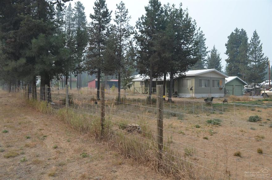 One acre corner lot with 2 bedroom, 2 bath, 1980 manufactured home. This 1440 sf home has 2 bonus rooms, 2 car detached garage with an enclosed service porch between the home and garage, 10x15 pump house/shop with trap door to well, and a 3 bay pull barn.