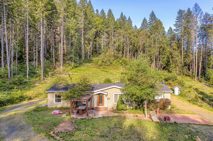 Looking for recreation, privacy and a peaceful setting?  This property is a recreational dream nestled on 4.56 acres, located .6 miles from Lake Selmac, backed by 120 acres of BLM, and featuring a large 36'x56' foam insulated shop with concrete slab, wired for 120 and 220V with a separate meter, 2 electric overhead doors, a flex room and a 12'x36' storage loft.   This 1782 sq ft 3 bedroom/2 bath home has been beautifully updated and features newer Hardie plank siding, vaulted ceilings, Acacia hardwood flooring, Mendota gas fireplace, both a living room and recreation room, well-appointed kitchen with granite marbled countertops and solid cherry wood cabinets, mobile island, and stainless steel appliances.  Split floor plan with an ensuite primary bedroom which includes walk-in closet, dual vanities, dual head tiled walk-in shower, and soaking tub.  Outside, relax and enjoy the peaceful setting on the front paved porch which has a pergola and gas fireplace.