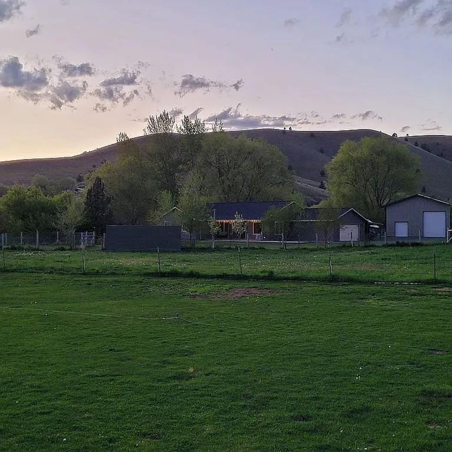 This beautiful and well built custom home sits on 1 acre down a gravel driveway away from the highway. Water rights for irrigation. Fantastic views of the Blue Mountains from the covered trex deck front porch!This property has fruit trees & large fenced areas in the front & back for animals, gardens etc.RV storage area. 30X36.5 shop built in 2021, 2 roll up doors (large one is 12ft high by 10 foot wide.12x16 storage shed w/loft. 11X12 covered dog kennel, chicken coop,21x23.5 garage attached to the house w/an additional covered carport. Inside the house you will find beautiful bamboo hardwood floors throughout, w/ tile floors in the kitchen, laundry rm & bathrooms. The kitchen has vaulted ceilings, stainless appliances & a double oven.The large great room has vaulted ceilings with a ceiling fan.The large master bedroom has a walk in closet, vanity with 2 sinks, walk in shower & soak tub.Home is on city water & sewer. Setting back off the highway this home is in a nice quiet location