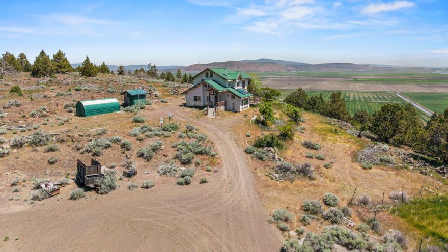 Off grid, hillside home on 120 acres near Worden, OR.    2 Bedroom, 2 Bath with panoramic valley & mountain views.   This one will need some work, but it will be worth it.   Main floor has a spacious kitchen & living room, dining room, 1 bedroom, 1 bathroom and laundry room w/storage & sink.  Upstairs you'll find another bedroom & bathroom and a cozy loft plus a small space that could be used as an office area.   Other features include; tall, vaulted ceilings, many windows to capture the views, large sunroom, metal roof and a deck.  Powered by Solar & Wind with generator back up.  For heat there is a woodstove and radiant floor heat.   Propane has been plumbed to some appliances. Sold AS-IS.  Seller unable to do any repairs.