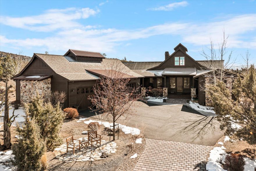 Captivating one level rustic home that accentuates a more traditional stately western narrative which abuts to a rugged common area with vast desert terrain and Cascade Mountain views from the large covered back deck. Featuring a large, welcoming front porch this home has a comforting sense of arrival as you transition to the foyer. Once inside, the home is ideal for the entertainer with an open plan vaulted great room and masonry fireplace which offsets the dining room and kitchen. The kitchen features stainless steel appliances and a spacious walk-in pantry. Slab countertops and a large island perfectly set the stage for the home chef. Rustic hardwood floors carry through all of the main living areas of this home. The primary suite offers a stone fireplace, walk-in closet, soaking tub, and patio access to the back deck and hot tub. Additionally, you will find two bedrooms opposite the primary bedroom with a full bath. An expansive three bay garage finishes this beautiful home.