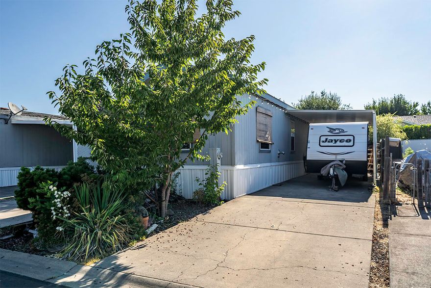 Welcome to this updated 2 bedroom, 1 bath MFH built in 2013 and located in a Family Park. The park rent is $377.00 which includes the water, sewer and trash. This lot has plenty of parking, including RV parking up to 25FT RV. with sewer hook ups. Two storage sheds, one is a workshop with power and workbench, the other shed is a garden shed. The backyard is fenced and private, decking, pond, 4 Hazelnut trees, 1 Cherry tree, and more. The home has pellet stove, laminate flooring, oak kitchen cabinets, range/oven, microwave, dishwasher, ceiling fans, come view this home located in Desert Mobile Estates.
