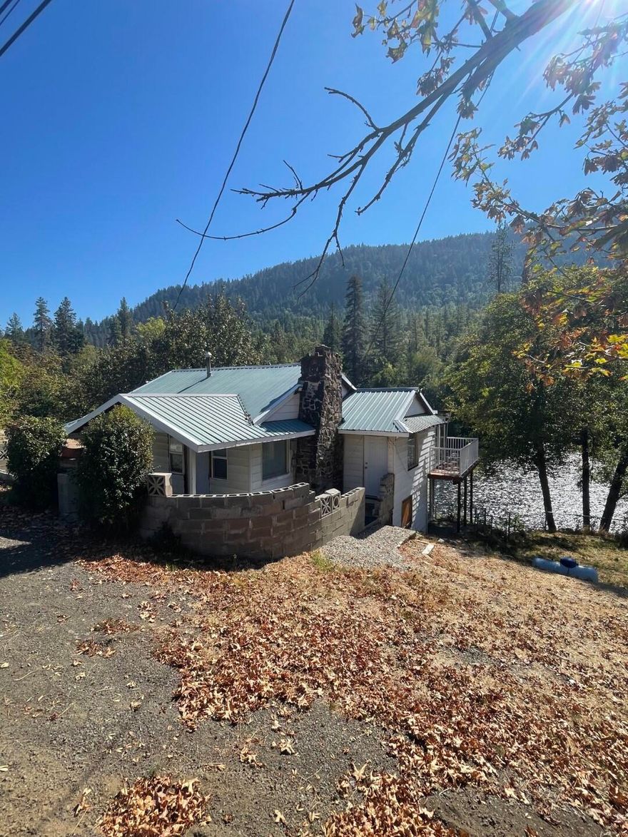 Rogue River Frontage*Investor Alert! Looking for an great opportunity on the Rogue River? Look no further! W/2 tax lots, this beautiful riverfront property has a stick-built home on 1/2 acre+. Backyard is peaceful and boasts great views of the trees, hills, and the fabulous Rogue River. Home has a custom private deck overlooking the water & offers plenty of opportunity. Sellers also built an additional small deck in the trees for viewing the water, +there's a small shop. Huge, flat side yard w/plenty of room for pool, 2ndshop, or? Metal roof, granite countertops, propane tank, newer laminate flooring, some newer windows, newer ductless heating & air, + more. Main floor has a huge living room overlooking the river, 2 small bedrooms, washer/dryer, bathroom, &  kitchen. Downstairs there are addt'l bedrooms and views.Cash only - possibly conventional sale. Some updates done likely completed by owner, leaving plenty left to be done to make this your perfect home. Just minutes to Shady Cove