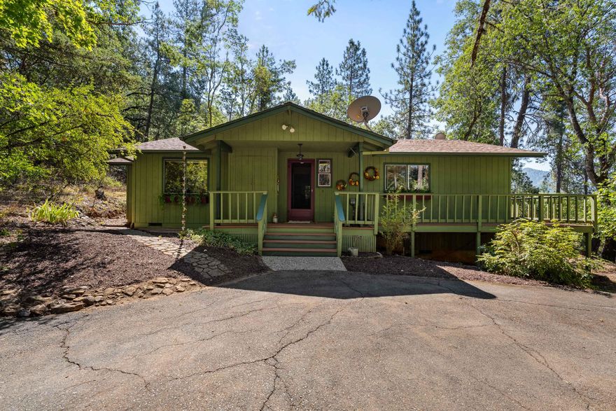 Enjoy privacy, peace and panoramic views from this super charming 2 bed, 2 bath Craftsman on 5+ private acres! This storybook home features a wraparound composite de k with breathtaking views of the surrounding landscape—perfect for relaxing or entertaining. Inside, you'll find updated LVP floors, cozy living room with woodstove and picturesque windows, nice sized kitchen that is open to the living space and primary bedroom with large soaking tub and walk-in closet. Outside is a true gardener's paradise with fruit trees, established garden, and a whimsical secret garden featuring an above-ground pool with brand new deck for summer fun. The property also includes a large RV garage, a separate workshop, and an adorable detached outbuilding ideal for an art studio, home office, or even guest space with a little finishing. Great well per well log! Peaceful, private, and packed with charm—this is a rare opportunity just minutes from town!