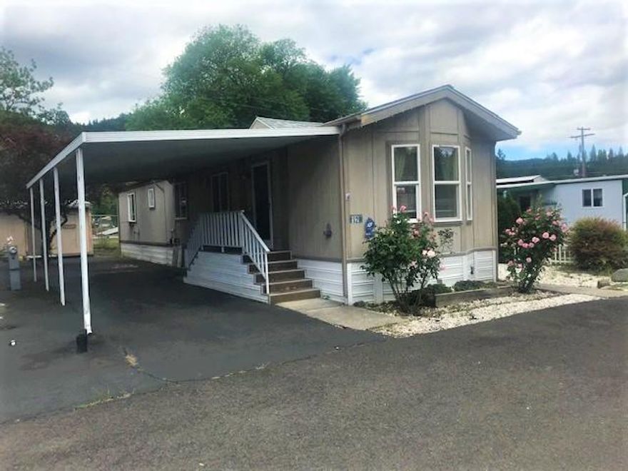 Nice single wide with lots of windows and vaulted ceilings throughout the home. Light and bright kitchen opens to the living room, nice large bath & master bedroom. New roof six months ago.  Attached carport plus large storage unit.  Other side of manufactured home has a raised deck with great sun exposure and steps down to the fenced in back yard. This is a decent park with Hi-Land water and mature landscaping.