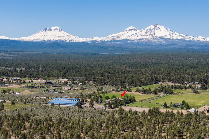 Owner will carry! Stunning 25.12-acre estate with unobstructed Cascade Mountain views and 11 acres of irrigation. The impressive 9,075 sqft 4-car garage home, offers 6 bedrooms, 6.5 bath and showcases granite kitchen counters, hardwood floors, and a soaring 30' VG cedar ceiling. Main-level primary suite includes a see-thru fireplace, spa-like bath with jetted tub. Features include a library, office, game room, guest suite, and a guest/staff apartment with a kitchen, bath, and laundry. Smart Lutron lighting/music, 9 heat pumps, zone-controlled heating, gourmet kitchen with Dacor stove and Subzero fridge. Enjoy the 990± sqft pool house with bathrm, steam shower, and sauna. Relax at the outdoor pool with slide, hot tub, and nearby Finnish sweat shed. Massive 26,539 sqft indoor arena perfect for motocross or horses, with stalls, tack rooms, paddocks, kitchen, full bath, and loft with viewing room. Gated property includes 375 spruce trees, fenced/cross-fenced, pasture, and two RV hookups.