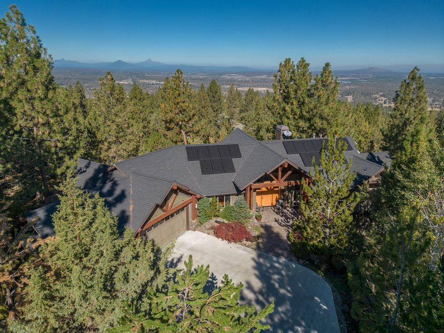 Timeless Northwest architecture by Norman Building & Design in the heart of Bend's Westside! Situated on a premier .87 acre lot on Awbrey Butte overlooking the breathtaking Cascade Mountains, this inspiring setting offers privacy, quality craftsmanship & an exceptional floor plan throughout. Great Rm features stunning natural design elements: dramatic timber beams, stone fireplace, cedar ceilings & an exquisite wall of windows framing the Cascades. Chef's Kitchen w/granite slab, stainless appl & expansive island offers access to the covered back deck for al fresco dining & entertaining. Private main level Primary Suite w/spa-like BA, generous walk-in closet & majestic views. Spacious main level home office w/2 work stations. Lower level offers space for everyone with 4 additional Bedrooms, 2 full BA & FANTASTIC Bonus Rm. Energy efficient solar panel system + 3 car garage for all your Bend gear. Delightful backyard, tranquil water features & multiple outdoor areas to enjoy year-round.