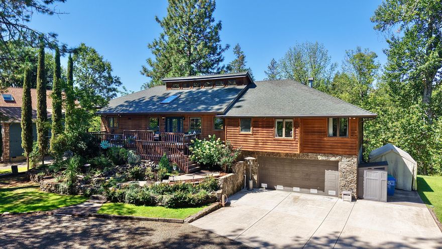 Rustic elegance meets modern comfort on the banks of the Rogue River. This 3-bedroom, 2-bathroom home offers 2,668-sq. ft. on the main level plus a 2,059-sq. ft. mostly finished basement with multiple flexible rooms. The open floor plan features vaulted ceilings, abundant natural light, formal dining, and a gourmet kitchen with custom cabinetry, pullouts, and newer stainless appliances. Expansive windows and a large back deck capture gorgeous river views, perfect for entertaining or quiet evenings. The luxury primary suite includes a fireplace, soaking tub, and oversized walk-in shower. Custom woodwork, wood floors, and newer luxury carpet elevate every space. Park-like landscaping with a water feature, irrigation from the river, RV parking, an oversized 2-car garage, and attached workshop complete the property. With easy river access and world-class Rogue River fishing out your back door, this home offers peace, beauty, and lifestyle all in one.