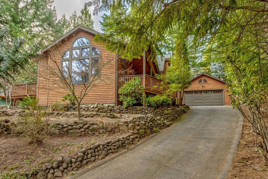 Just a few blocks above Southern Oregon University, 945 Penny Drive is worlds away. 3br, 2ba and small office. You will love the idyllic pine setting in a Lake Tahoe-style retreat. Rustic among trees and situated on a rare Ashland cul-de-sac, this custom retreat is a private oasis. The light and bright great room with its huge windows overlook mature trees. The forest-like neighborhood reminds us of nature all around, especially with only a few houses on Penny Drive. Family and friends can sit outside on inviting decks right off of the great room, as well as upstairs. There's room for visitors and guests to park their vehicles on the long, paved driveway, or in the 2-car garage. Also, a TID canal is behind the backyard, and we love that this property has irrigation rights.