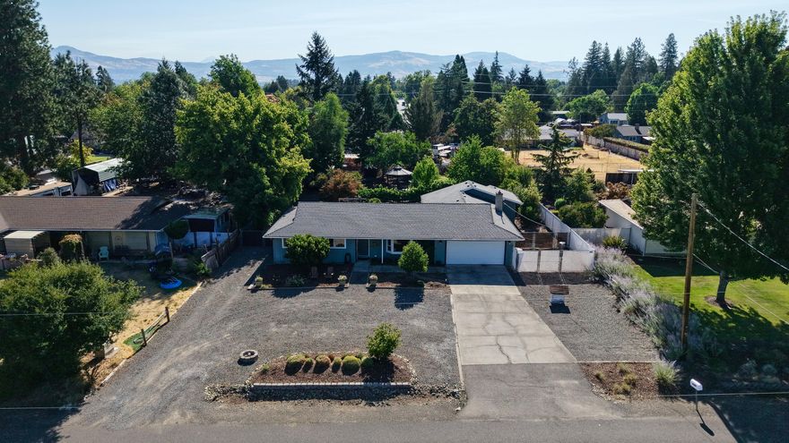 Completely remodeled in 2024, this 3-bdrm + office (or optional 4th bdrm), 2 bath home offers modern updates & timeless country charm on nearly half an acre in the desirable Griffin Creek School District-just minutes from Jacksonville! The open & spacious 2,015 sq. ft. layout features premium wood laminate flooring throughout & is filled w/natural light from oversized windows.  Beautifully updated kitchen w/quartz countertops, built-in breakfast nook, custom cabinetry, garden window above the sink & new stainless-steel appliances.  The living room boasts a bay window with views of the West Hills, while the large family room offers a gas fireplace and plenty of room for entertaining. French doors in the primary suite open to the private back patio.  The outdoor space includes a gazebo, grape arbor and fruit trees.  RV barn w/dump station, circular driveway & attached 2 car garage.  City sewer, private well & a quiet location adjacent to orchard property complete the package.