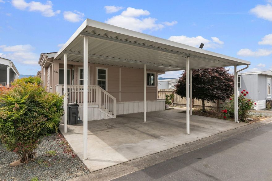 Pulling in into your own covered carport, maybe smelling your roses that are resting on freshly installed bark or just making your way up the stairs of your front porch to open the door to your own paradise. Welcome home to this stunning 1,782 sqft home equipped with office/rec open space, kitchen, living room, dinning room, laundry room, 2 full bathrooms, 3 bedrooms & a den. This freshly painted inside & out manufacture home with new light fixtures, & brand new laminate flooring feels better than new! The tray ceiling in the living room adds that perfect dramatic effect. Vaulted ceiling throughout the house for that spacious feel. Kitchen has tons of cabinets & counter space- a chef's dream! Master bedroom has an ENORMOUS walk in closet. Huge master bathroom with two separate vanities, an elegant corner tub & a shower. This home is equipped with all appliances and new skirting. Enjoy the future new clubhouse in this ALL-AGE PARK. But hey, you already know— this home was made for you!