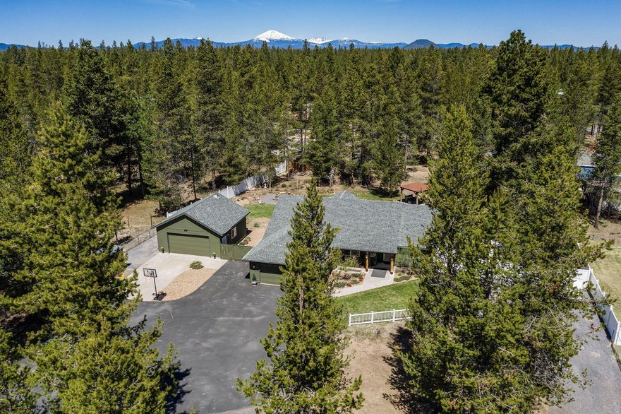 Truly charming, fully updated single-level home at the paved end of Sunrise Blvd. The open concept great room features vaulted ceilings, a gas fireplace, and custom live edge wood countertops. French doors lead to a fenced, park-like backyard designed for both relaxation and fun, with a covered deck, fire pit, gazebo, hot tub, and horseshoe pit. The primary bathroom has been updated with a large spa-style shower, double sinks, and two closets. The 4th bedroom is currently set up as a music room with a dry bar but could also be used as a home office. This home includes RV parking and a second 576 sq ft garage that works great as a shop or hangout—fully insulated with epoxy floors and built-in storage cabinets. La Pine is an outdoor paradise with easy access to lakes, fishing, golf, hiking, and winter activities.