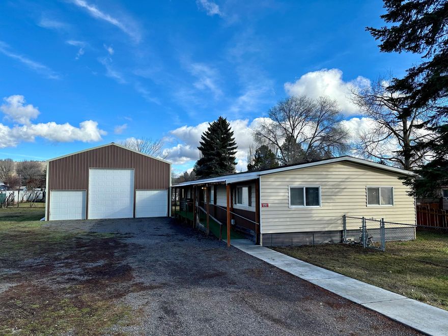 Giant shop with cement floor and insulation, shed with power, and 3 bedroom 2 bath manufactured home on 0.39 acres. Lots of parking in addition to the triple bay shop with automatic roll up doors. Rv parking with hookups. Newer (<1 year) deck with roof, gas stove, hot water heater, and washer.  Ramp from street to front door and an ADA shower. Most appliances included. Easy to show.
