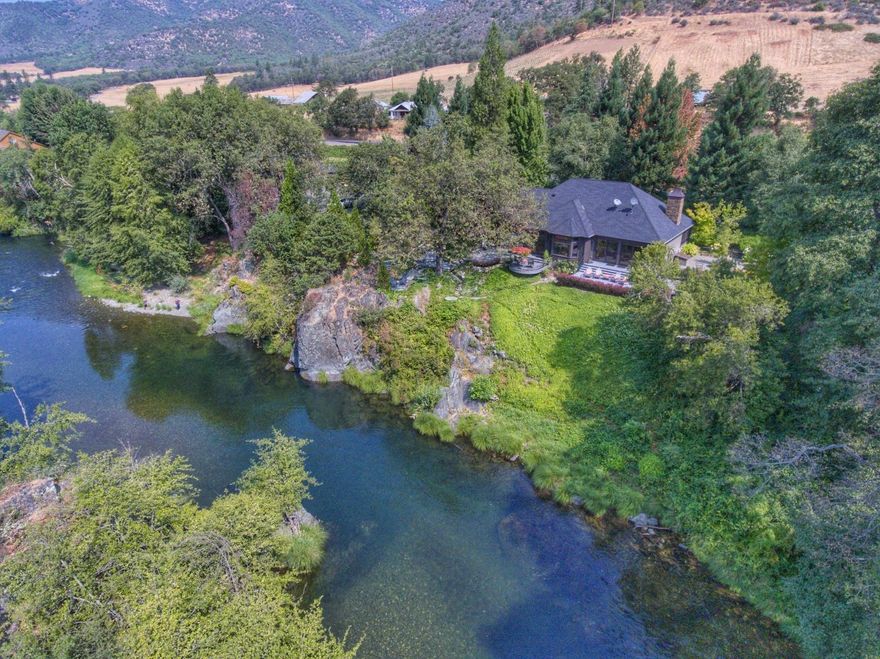 Looking for Real Beauty aside the Applegate River? Take a look at this home perched on a huge Granite Rock. Watch the ducks and geese share this beautiful waterway where you can swim, fish or watch the fun with a glass of your own wine. Smitten is the smallest Bonded Winery in the heart of the Applegate Valley. Vineyard planted in 2008 w/ Tempranillo, Syrah & Merlot. Main house was remodeled down to studs in 2009 w/ Geothermal HVAC, Sierra Pacific windows, high ceilings, hardwood & stone floors. Beautiful kitchen w/ sub-zero, Wolf appliances, Granite island & custom cabinetry throughout the house. Gorgeous landscaping, private estate setting w/gated entry, paved driveway. Garage built in 2007 has oversized 3 car insulated garage, HVAC system in shop/winery & upstairs guest space with wood floors, beamed ceiling; farm equipment carport & RV parking. 2 Barns adjacent to Humbug Creek hold hay from 10 acre field. 1918 Water Rights! Sequoias & Cedars surround this gorgeous land.