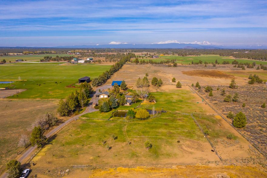 New roof just completed for this open concept farmhouse on 10.1 acres just 10 minutes to Costco. A beautiful pond, for the 3.5 acres of COID irrigation, creates a great setting for this private & wildlife filled country retreat. Awesome Cascade Mt views from property & updated house w/ great flow & function. 5 bedrooms, large pantry/laundry room, & separate mud room make it easy for big families, added guests, or entertaining. Oversized detached 2 car garage w/ separate 440amp service, tons of storage & 300sq ft insulated office/workout/guest room. 2160sq ft shop built 2018 has 12' roll up doors & additional 800sq ft covered outside storage. Fenced, x fenced, stalls, shelters, deer fenced garden w/ fruits, berries, herbs, perennials, raised beds, & greenhouse. New heat pump, DW, fridge, too much to list! Room to make it yours w/ 5+acres out front & market garden ready for crops, lavender, hemp or? Make epic sunsets & starry nights part of your daily routine! Property not a drive by.