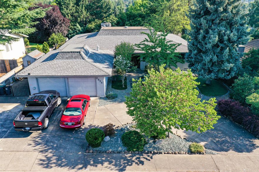 Spacious one-level residence in a popular mature close-in East Medford neighborhood. Set on a large private lot on a quiet no-through street. Updated and remodeled over the years including a granite kitchen and new wood flooring in the main living areas. This convenient floor plan offers a large peninsula kitchen with lots of cabinets overlooking the dining area and a huge great room with built-ins. Besides the open great room you'll enjoy the formal living room with high ceilings, a wall of glass looking out to the covered patio and a masonry rock fireplace - converted to natural gas logs. Three spacious bedrooms - two with ensuite bathrooms plus an office/bonus/hobby room that can easily be made into a fourth bedroom. A half guest bath is off the entry hall. Easy-care grounds bring privacy with mature landscaping. Your guests will like the circular driveway and extra parking on the side for a small RV, hauling trailer or boat. Oversized 632 sq. ft. garage.