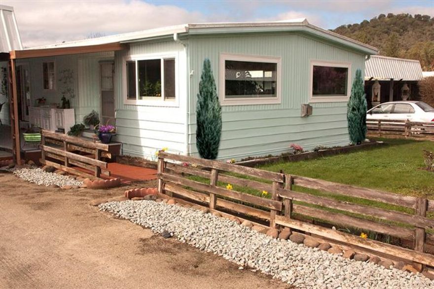 Don't let the age deter you from seeing this beautiful, totally remodeled home! It is truly a gem! Located in the very desirable 55+ Nestled in the Hills Manufactured Home Park! All new plumbing, new roof, sinks, Toto toilets, electric, fixtures, Corian countertops, Berber carpet, vinyl, interior & exterior paint, windows, French doors, island w/Corning cooktop, designer glass vent over the stove, cozy propane fireplace, walk-in closet, custom blinds & a lovely covered patio. (See attached list of updates) There is lots of storage off the carport and a large shed in the spacious backyard. Park space is very large with no other homes behind you. Included is the dining table & chairs along with the large sleeper couch in the living room. Absolutely move in ready! This is country living at it's best!