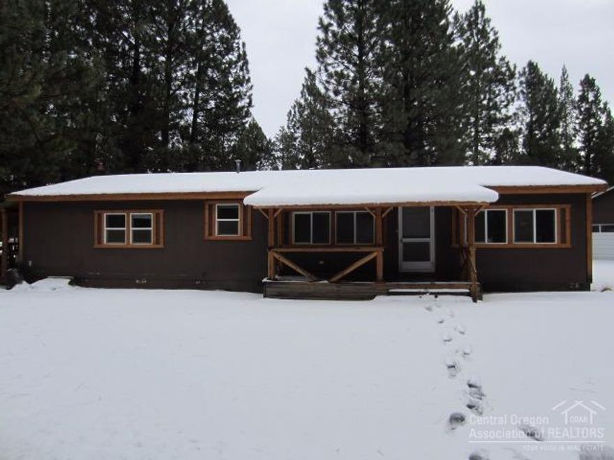 Wonderful opportunity nestled in the pine trees on a private 1 acre corner lot. This home has an open floor plan with vaulted ceilings and great master separation. Keep comfortable year round with a woodstove and air conditioning. The exterior has some great features such as a paved driveway and a metal roof. 26x40 finished shop with overhead door, large storage shed and fenced with a gated entry. Needs some TLC but an excellent investment opportunity.