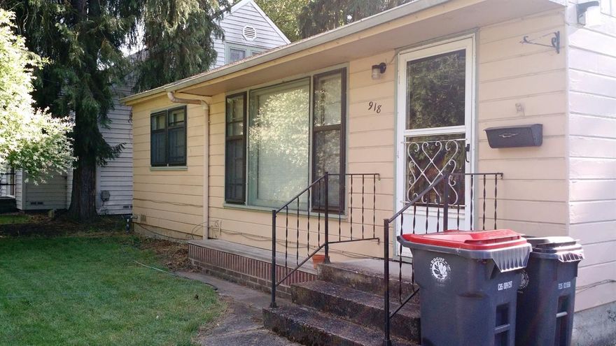 Cute 1950's cottage on a quiet street on a huge fenced lot. Alley access to the big back garden area that also has room to park an RV between the fruit trees. Original 1950's metal kitchen cabinets from Youngstown Kitchens by Mullin are immaculate. Original oak floors are in great shape. Darling floor plan with a natural gas stove insert in the living room for cozy nights. Dining area off the kitchen by the back door for convenient access to the deck for summer BBQ's. Indoor laundry room off the kitchen as well. Fully fenced back yard. Single car garage is immaculate and has a nice shop attached.