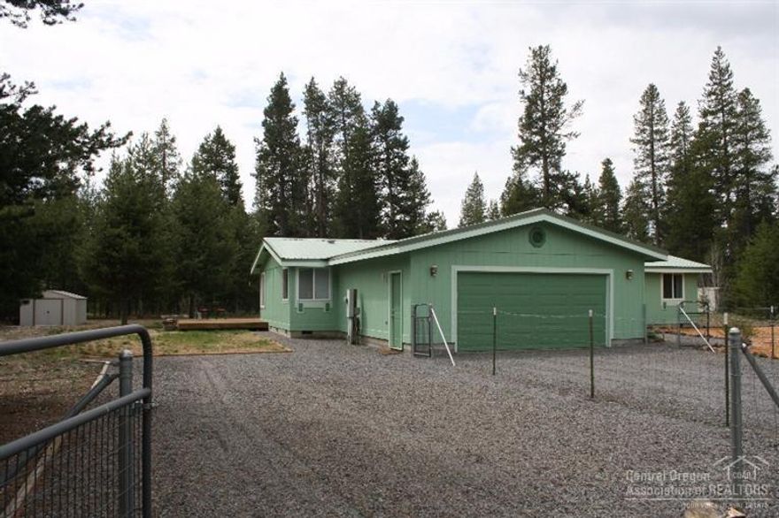 Exceptional manufactured home on 1.25 acres. Very well maintained, landscaped, laminate flooring & many more upgrades throughout. Two car attached garage, exterior deck and small outbuilding. Approx 1500 SF of open living space. Three bedrooms, two baths w/add'l office space. Large kitchen, master bdrm on East side, add'l bdrms on West side. This home shows pride of ownership and is a real charmer, clean and tidy! A must see!