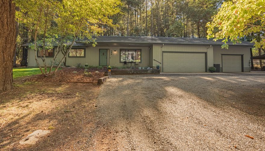 Nestled on 2.86 acres of lush woodlands in this 3-bed, 2-bath home spanning 1652 sq ft. Recently revitalized, it features fresh paint, new appliances, and new flooring. The airy kitchen, equipped with a convection oven, adjoins a dining room and living space, complete with an eat-in bar. The primary bedroom is bright and airy, with sliding glass doors that lead to serene outdoor views. The spacious primary bathroom offers extra storage. Hobbyists will relish the 110v-powered shed and a 3-bay heated garage with 220 power. According to the Oregon well log, this homes well yields 20 GPM.  The house features a circle drive, carport, RV hook ups with dump, and partially fenced yard, making it perfect for those who desire a peaceful lifestyle.