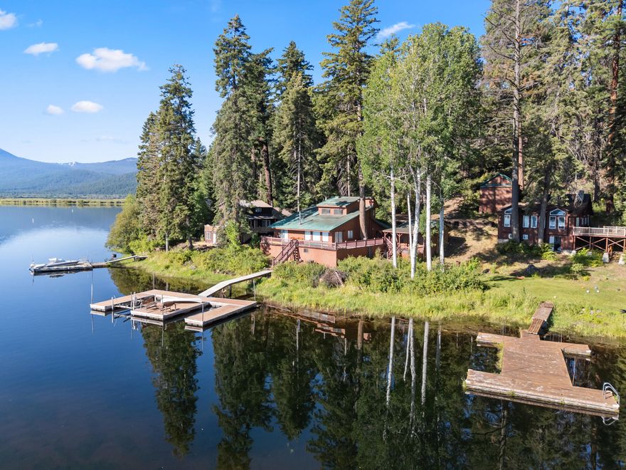 One of the Best Waterfront Cabins in Rocky Point! Discover a truly special waterfront retreat on scenic Upper Klamath Lake. Perfectly positioned near the Boat Launch and Rocky Point Resort, Cabin A-7 sits on one of the most desirable spots along the shoreline — a clear, spring-fed section of the lake, renowned for its ideal fishing right off the two-bay dock and expansive decking. This charming, updated cabin offers a generous wrap-around deck, a spacious living, family rooms with both a wood-burning fireplace and a wood stove, and breathtaking views of Klamath Lake from nearly every window. Rare for the area, the property includes a two-car garage, additional parking, and an outbuilding featuring a bunk room and storage shed. Located on USFS land with a transferable special use permit, this is your chance to own one of Rocky Point's most unique and coveted waterfront locations