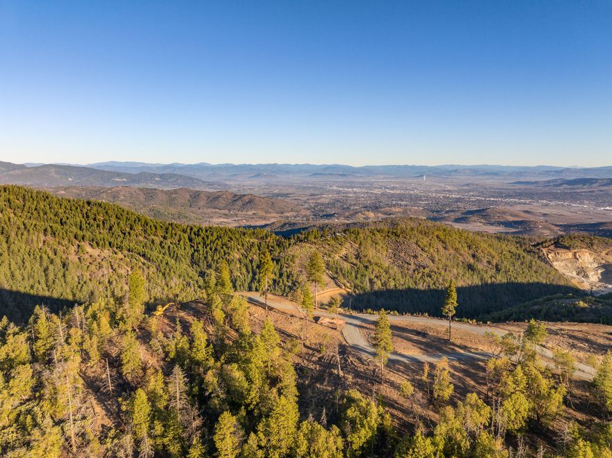 OWNER WILL CARRY - ONLY $99K DOWN - INTEREST ONLY at 6.5% - BALLOON IN 3 YEARS - Perched at an impressive 3,300' elevation, this land offers panoramic views of the Rogue Valley including the Crater Lake Rim, Mount McLoughlin & more. The elevation also provides a natural escape from valley fog, offering sunny, clear days.  The building pad includes a circular driveway & ample space for a custom home & multiple outbuildings along the ridge - additionally, a 21 GPM well is already installed. The property is teeming with wildlife, including blacktail deer, turkeys, black bears, & more, making it a retreat for nature lovers & outdoor enthusiasts. For those seeking even more space to explore, the property borders 7,000+ acres of BLM land on two sides. Despite its peaceful seclusion, the property remains conveniently close to modern amenities. It's located just 8-9 miles from Interstate 5 & the Rogue Regional Medical Center, with quick access to the amenities of Southwest Medford.