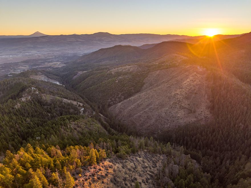 OWNER WILL CARRY - ONLY $99K DOWN - INTEREST ONLY at 6.5% - BALLOON IN 3 YEARS - Perched at an impressive 3,300' elevation, this land offers panoramic views of the Rogue Valley including the Crater Lake Rim, Mount McLoughlin & more. The elevation also provides a natural escape from valley fog, offering sunny, clear days.  The building pad includes a circular driveway & ample space for a custom home & multiple outbuildings along the ridge - additionally, a 21 GPM well is already installed. The property is teeming with wildlife, including blacktail deer, turkeys, black bears, & more, making it a retreat for nature lovers & outdoor enthusiasts. For those seeking even more space to explore, the property borders 7,000+ acres of BLM land on two sides. Despite its peaceful seclusion, the property remains conveniently close to modern amenities. It's located just 8-9 miles from Interstate 5 & the Rogue Regional Medical Center, with quick access to the amenities of Southwest Medford.