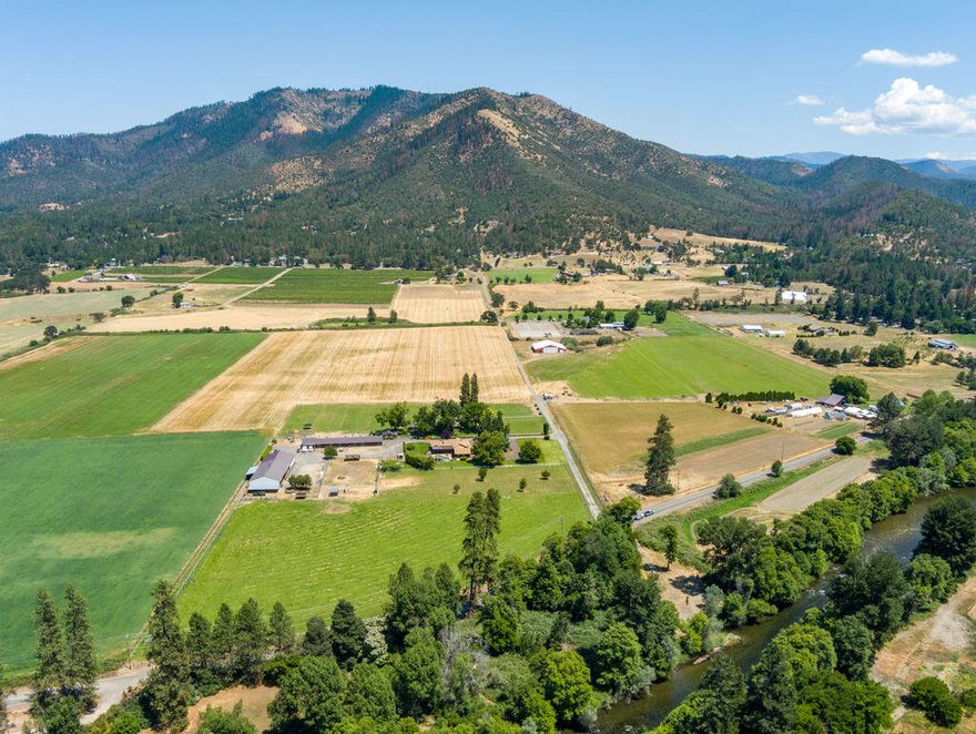 Riverstone Ranch conveniently located in the heart of Southern Oregon Wine Country just minutes to Jacksonville & Medford. Beautiful updated main home is one level log home w/open beam ceilings, 4 bedrooms, updates include flooring throughout, lighting, new kitchen, new bathrooms, water heaters, new appliances. Lots of patio areas & decking & an in ground Gunite pool. 2nd home with newer upgrades, 3 bedrooms, beautiful open kitchen to the great room. Separate studio/bunk house w/mini kitchenette, bathroom & mini split HVAC. Detached large office building. Park like setting w/1857 irrigation water rights & river access to Applegate river. Flat level land. 48x 48' insulated shop, 48' x 96' hay barn/covered riding arena, insulated 40' x 140' show barn w/ 3 tack rooms & a dog kennel. Fenced, cross fenced & gated entry.