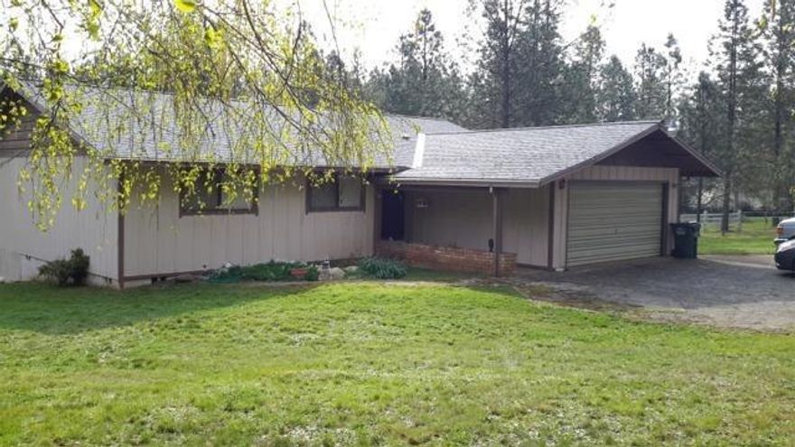 Beautiful back deck looking out at the mountains and trees. This is a nice comfortable 3 bedroom, 2 bath setting on a 5+ acre mini farm. Has fencing, chicken coop and small shed. Storage shed with carport attached. Room for RV parking and gated paved drive.