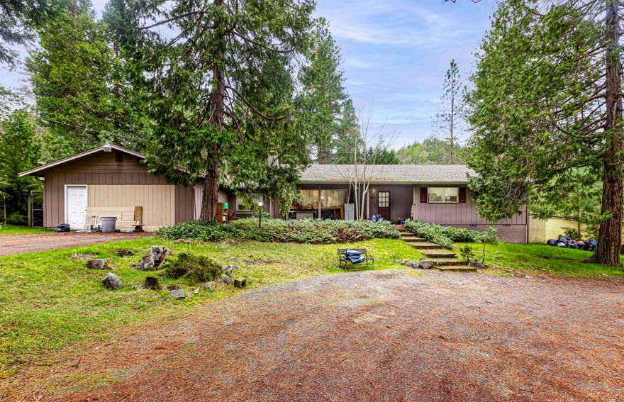 Bring your imagination, elbow grease and vision to this 3-bedroom 2-bath home and give it a new life. Absolutely fantastic neighborhood with mature trees , gardening areas , room to roam for children and fenced. Unlimited potential for redesigning inside - open spaces - Large floor plan. A stone fireplace greets you in the living room, while the kitchen Bankette offers a place to sit and chat while dinner is being prepared. The huge family room off the kitchen offers plenty of space for entertaining. A bonus room and even a space for an office give the home even more opportunity for your creativity. In need of some fixing and updates, this home has the potential to be a forever home. The mostly flat, nearly 1 acre slightly sloped property features a lovely gazebo and room for the chickens in the large coop, and more storage in the 2 sheds.
The garage is being remodeled into more storage space but could easily be converted back to a 2-car garage.