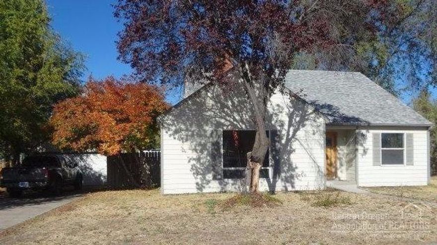 Vintage home on Prineville's main through street. Recent updating includes, exterior doors, vinyl windows, roof, siding, paint, complete kitchen including appliances, water heater & gas furnace. Refinished hardwood floors throughout the main level, formal dining & living rooms with fireplace, built-ins and arched doorways, spacious utility, 2 downstairs bedrooms. Two bedrooms and bath upstairs. Enclosed porch, large yard with ally access. Private well for watering yard with new pump and pressure tank.