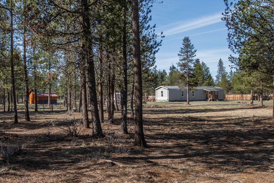Rural living 8 miles from La Pine out in a private and quite wooded area. Whether you're seeking a homestead, a recreational retreat, or an investment opportunity, this one has the bones and the setting to make it shine, offering a fresh opportunity for redevelopment.  The 3 bdrm/2 bath 1999 manufactured home has no stated value. This unique 5 acres is quiet and the perfect country setting that adjoins BLM land allowing you to ride your horse right out back, though the woods. The property is perimeter fenced making it ideal for a horse or other animals. Wildlife is abundant. The cozy rustic bunkhouse sleeps 4 making it a getaway retreat to enjoy lake fishing, hiking or hunting. Key improvement, the wildland fire hazard mitigation has been completed. All the essential utilities are in place; well, septic, and electricity.